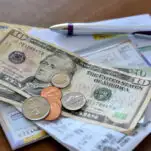 bills, coins and a check book on the table