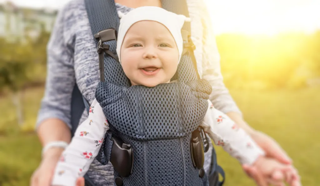 mommy using a baby sling carrier for her baby girl