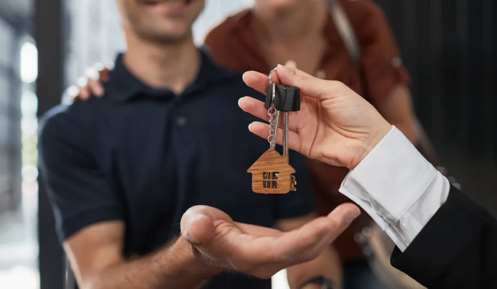 Sales agent handing over the house keys for their new house