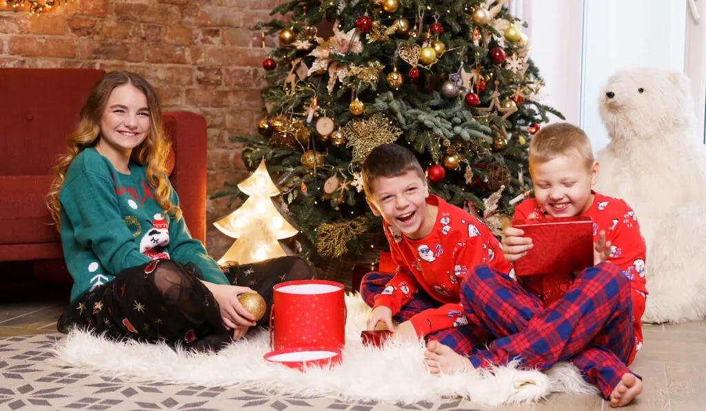 cheerful siblings opening gifts