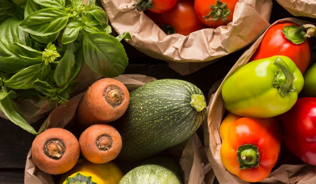 Close up of fresh eco vegetables in coton bags on wood
