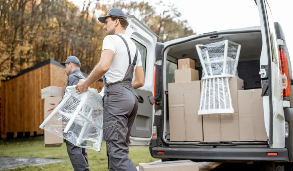 Delivery company employees unloading cargo van vehicle