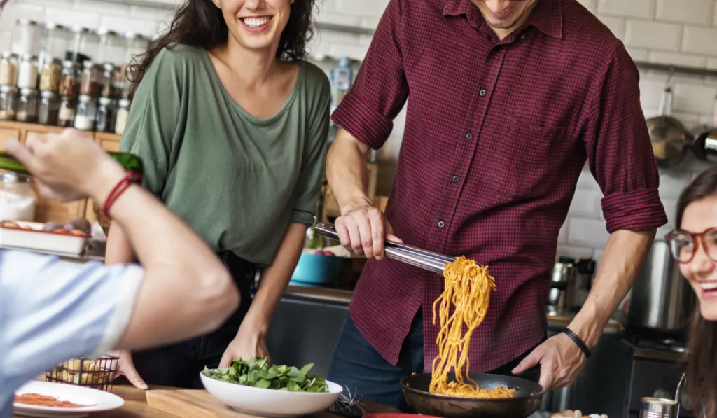 friends enjoying spaghetti and green salad for dinner