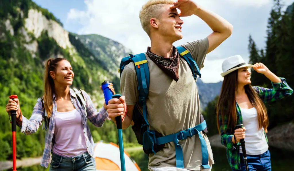 Group of happy hiker friends trekking as part of healthy lifestyle outdoors activity
