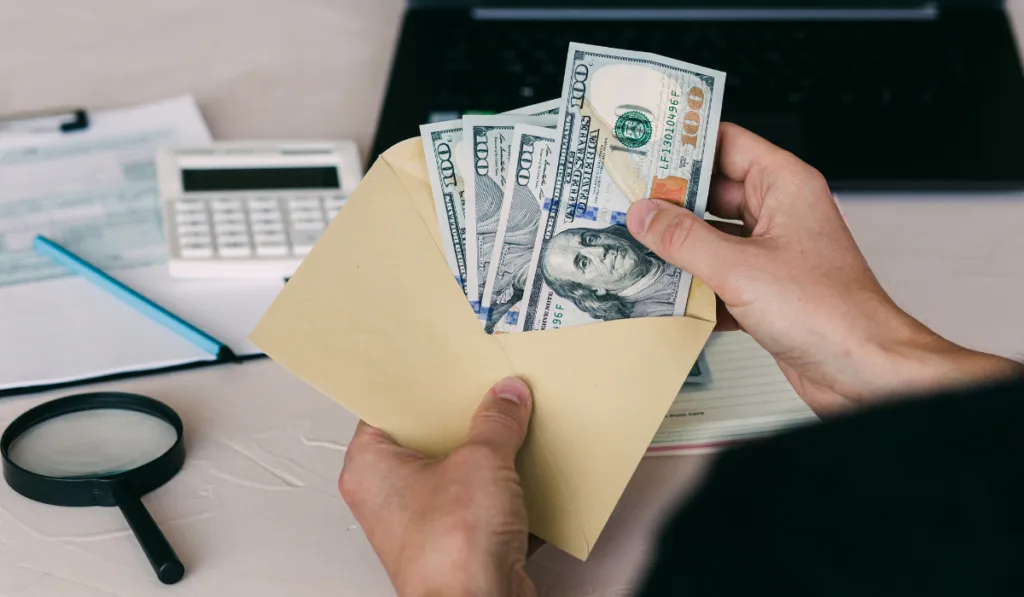 Man's hand holds envelope with money
