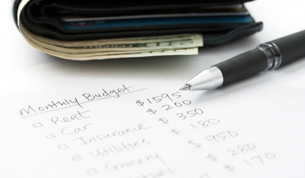 Monthly budget planning sheet with pen and wallet