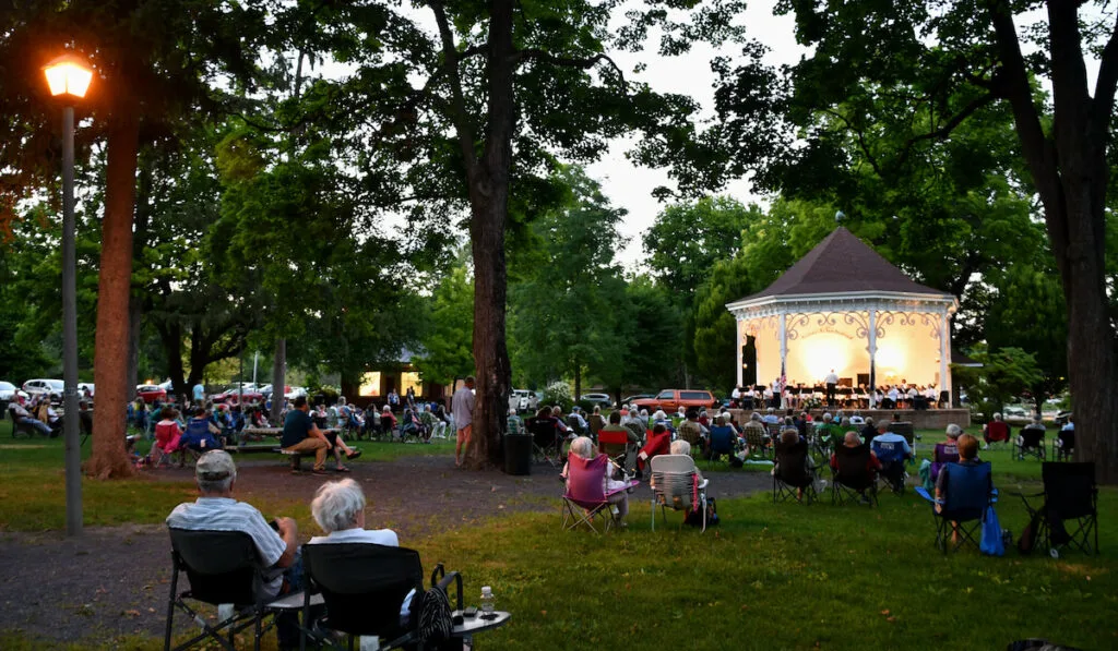 People in lawn chairs enjoying an outdoor concert at a park