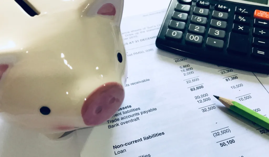 Piggy bank, calculator and balance sheet. Accounting concept
