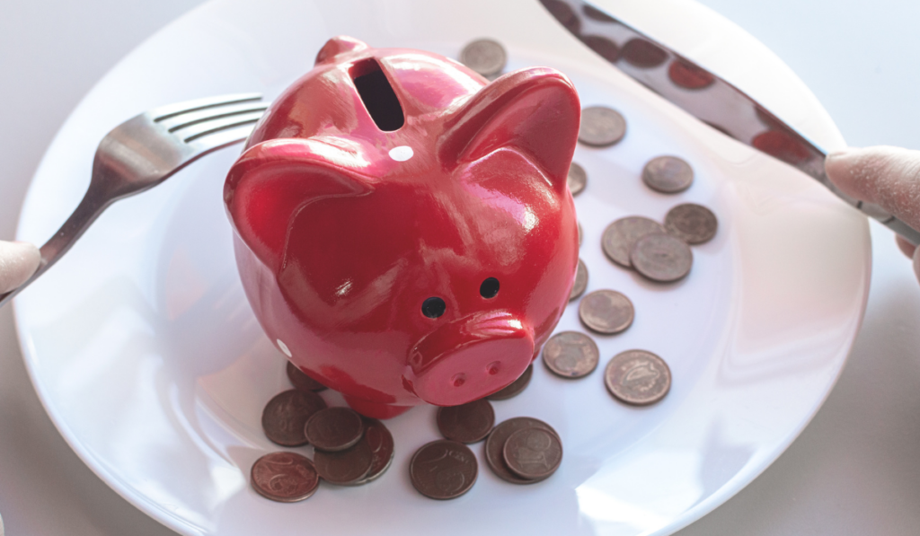 Piggy bank with coins stands on a plate