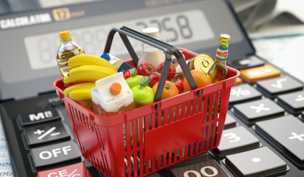 miniature shopping basket full of grocery on calculator.
