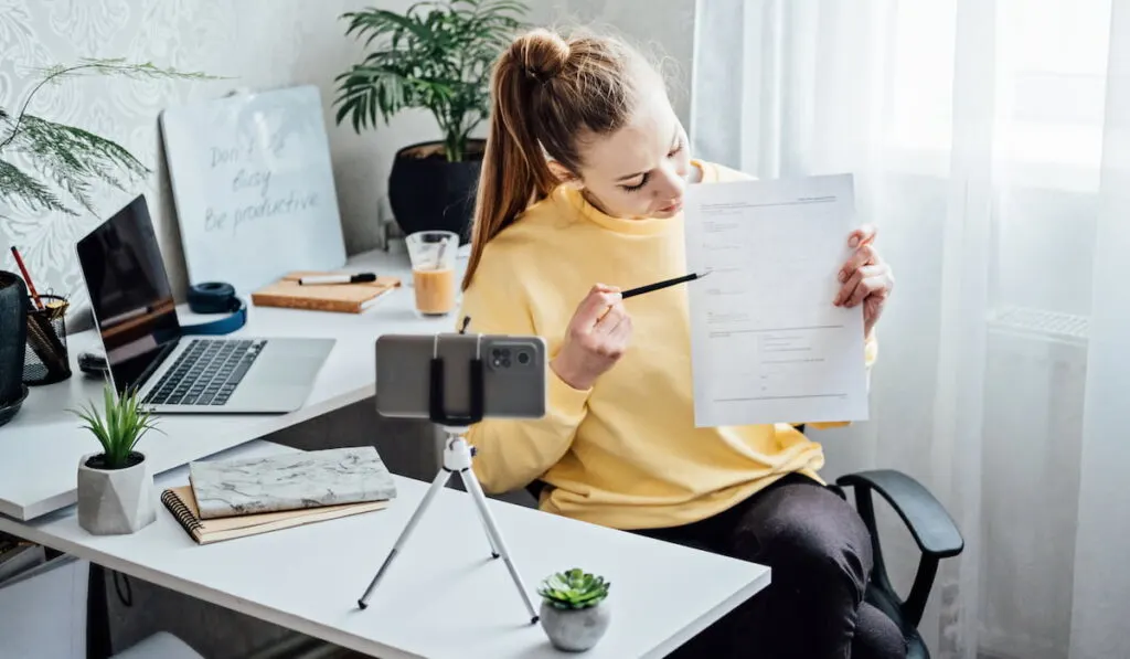 woman filming a video for her side hustle working from home