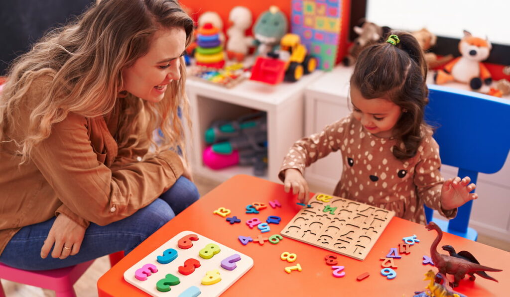 teacher and toddler playing with math puzzle