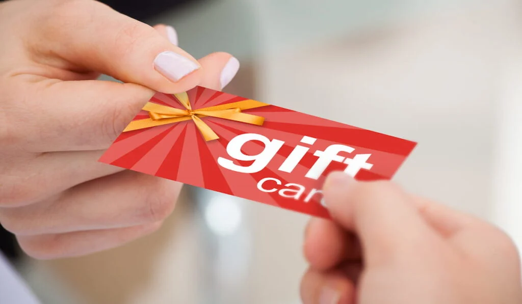 woman giving gift card to a friend