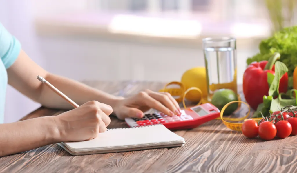 woman in the kitchen calculating cost of a meal