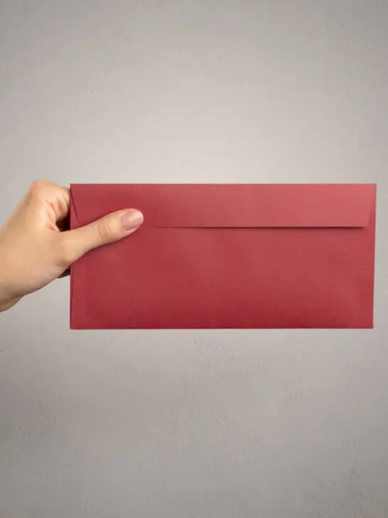 female hand holding a red cash envelope