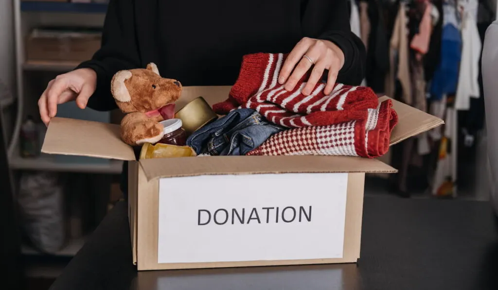 woman putting clothes in a donation box
