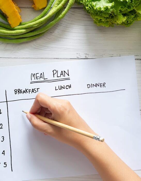 woman writing a meal plan for the family