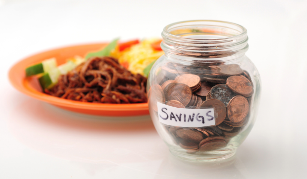 food plate on the table and a money jar beside it with label savings
