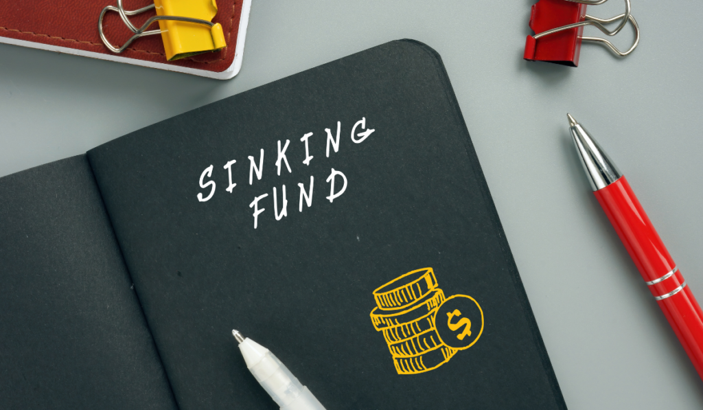 sinking fund black notebook and a red and white pen on the table