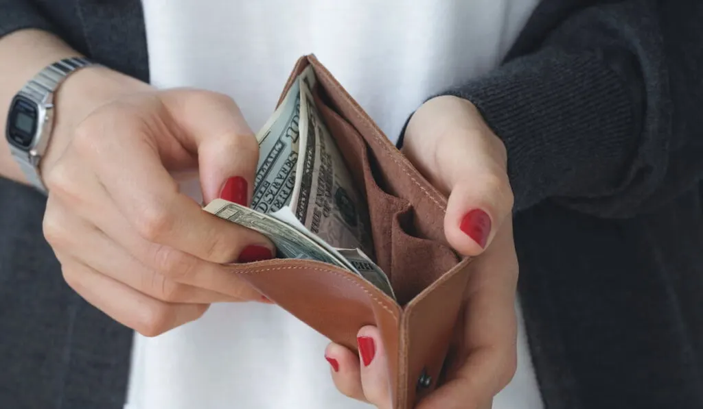 woman getting cash from her wallet 